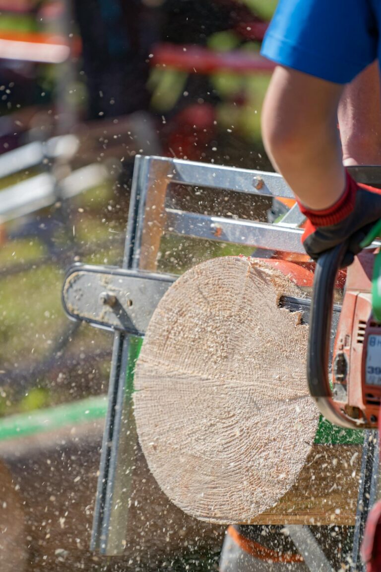 Dynamic close-up of a chainsaw cutting wood outdoors, wood chips flying.